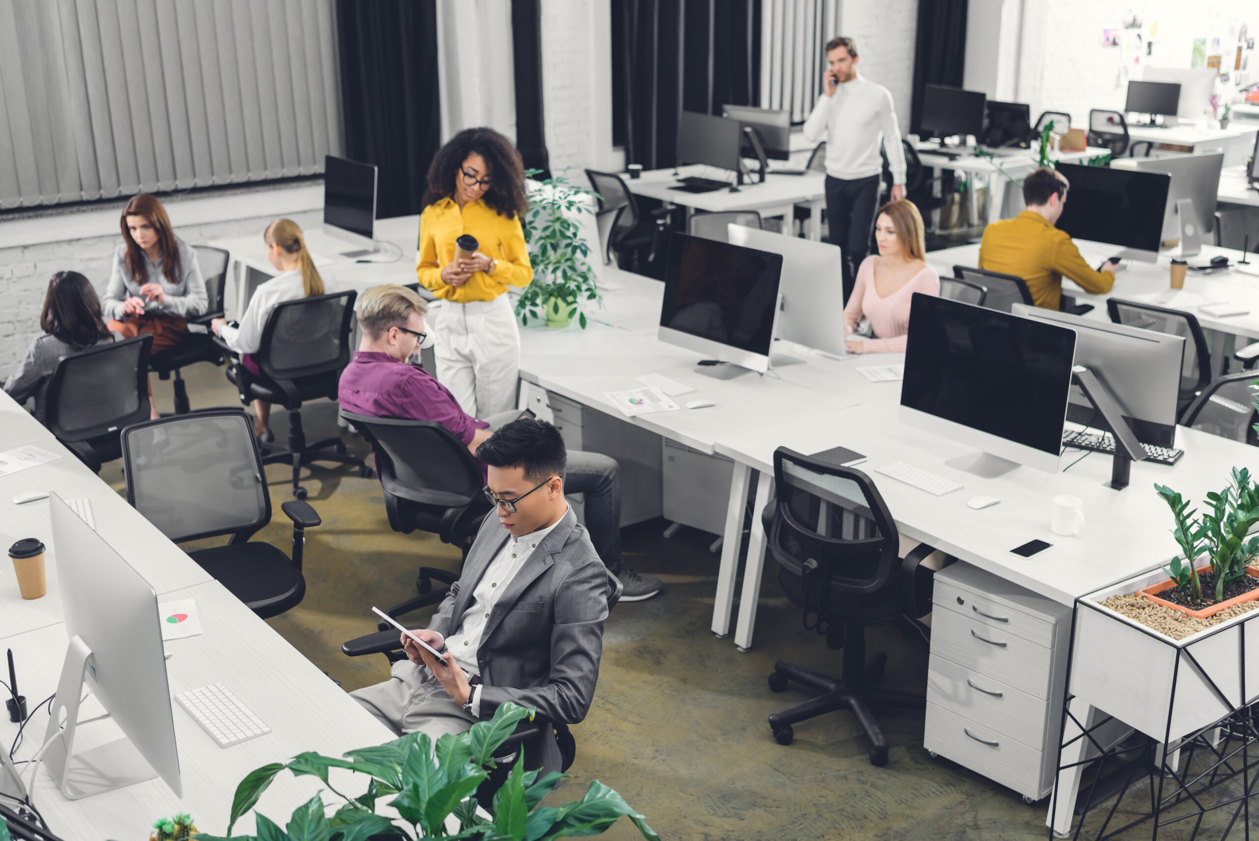 High angle view of multiethnic group of businesspeople working together in open space office